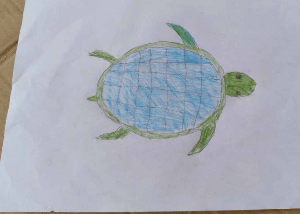 Completed leaf tracing craft showing a colorful, hand-drawn green and blue sea turtle.